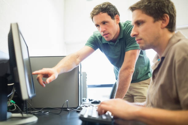 istock Teacher and mature student in computer room 846710792
