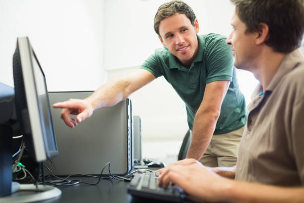 istock Teacher and mature student in computer room 846710822