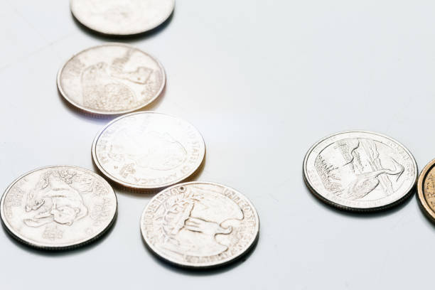 istock Brightly lit American coins scattered on white surface 846714728