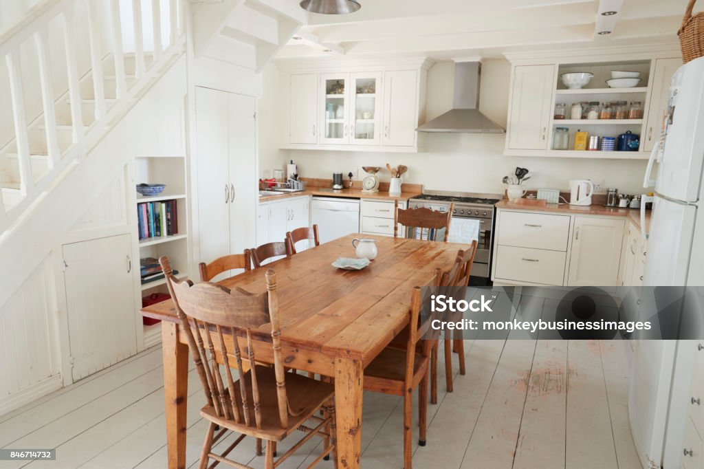 Vista interior de cocina con mesa de comedor de madera - Foto de stock de Cocina - Estructura de edificio libre de derechos