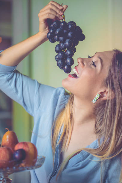 употребление винограда - plum eating women fruit стоковые фото и изображения
