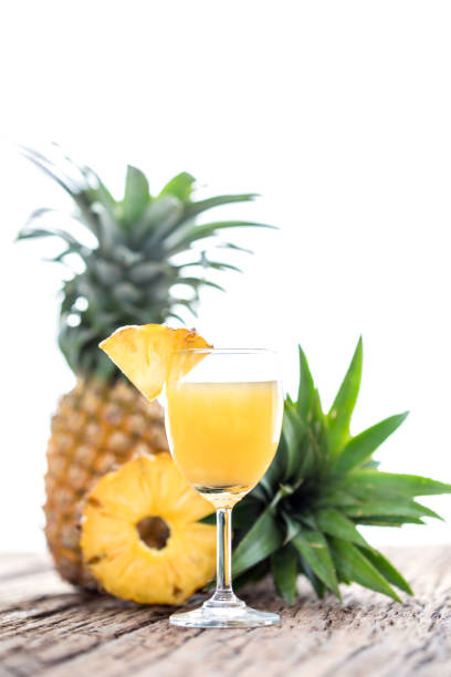 Glass of pineapple juice on wood table over white background