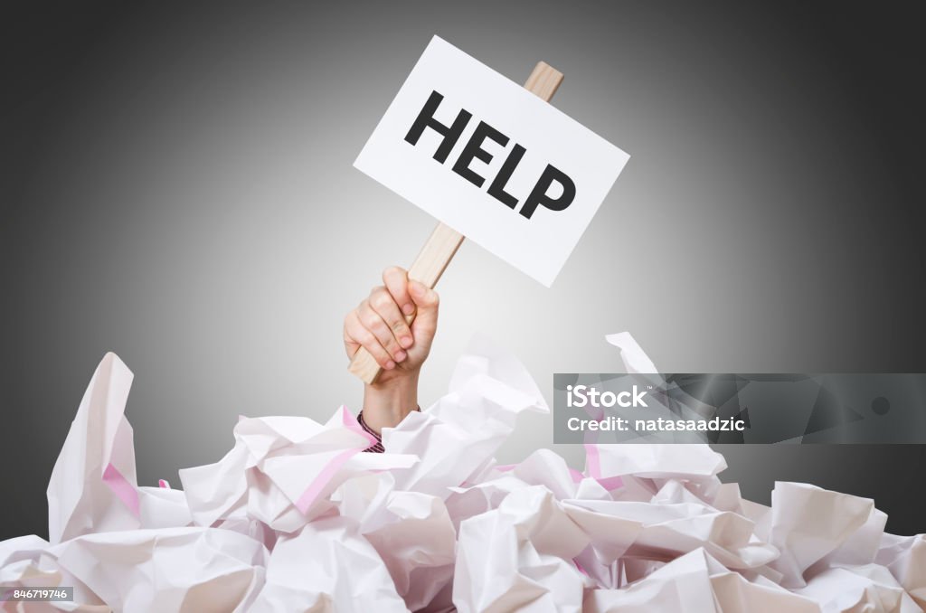 Help placard Help placard in hand with crumpled paper pile. A Helping Hand Stock Photo
