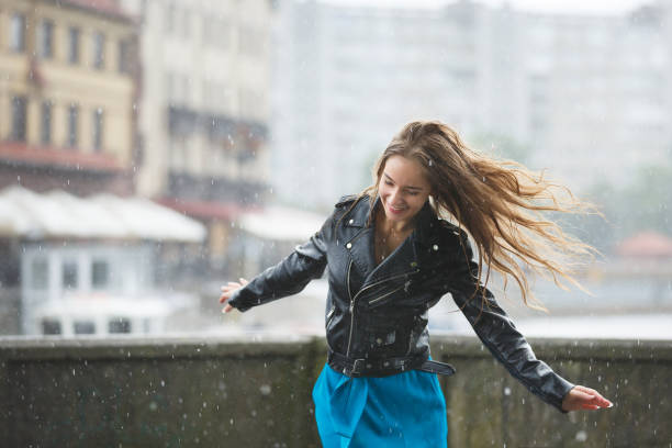 Happy young girl in the rain stock photo