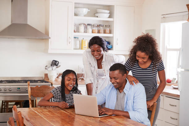 istock Family Around Kitchen Table Booking Vacation On Laptop Together 846722612