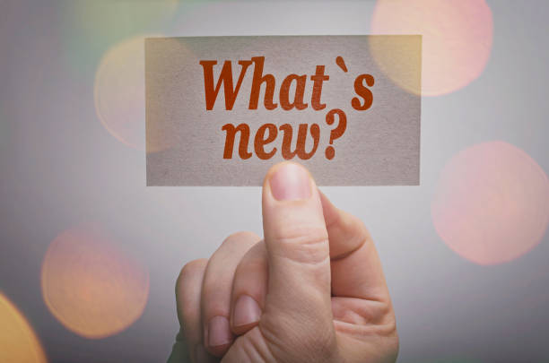 What`s new? card What`s new? card in hand with bokeh lights background release notes stock pictures, royalty-free photos & images