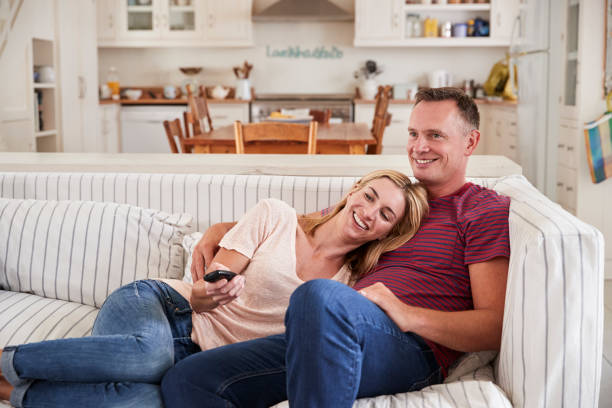 istock Couple Sitting On Sofa Watching Television Together 846727268