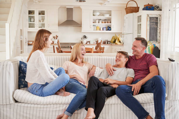 family with teenage children relaxing on sofa together - mãe filho conversa imagens e fotografias de stock