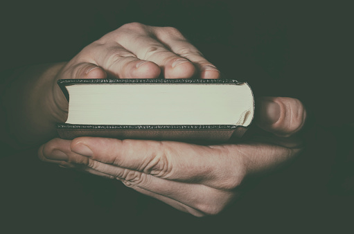 Hand with Holy Bible book. Freedom of religion concept.