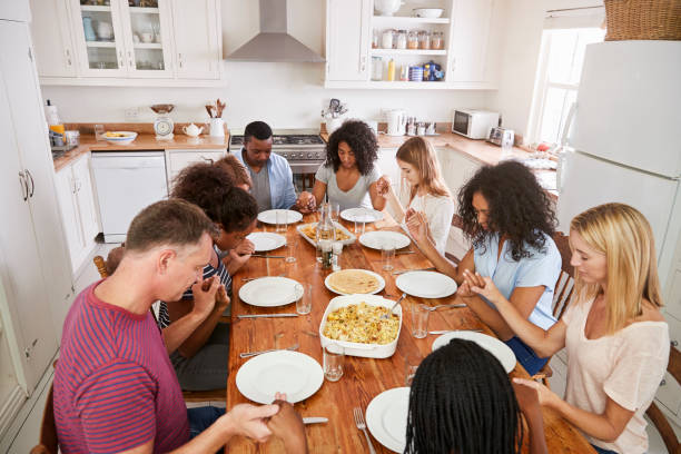 istock Two Families Saying Grace Before Eating Meal Together 846727844