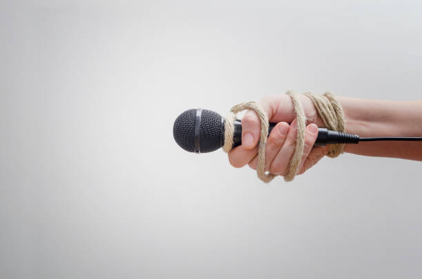 hand with microphone tied with rope - war criminal imagens e fotografias de stock