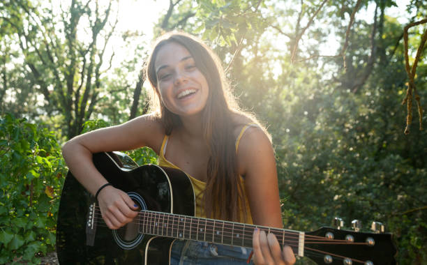 niña tocando la guitarra - niña tocando la guitarra fotografías e imágenes de stock