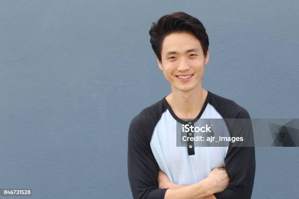 Young Asian Male Smiling And Laughing With Arms Crossed Stock Photo - Download Image Now