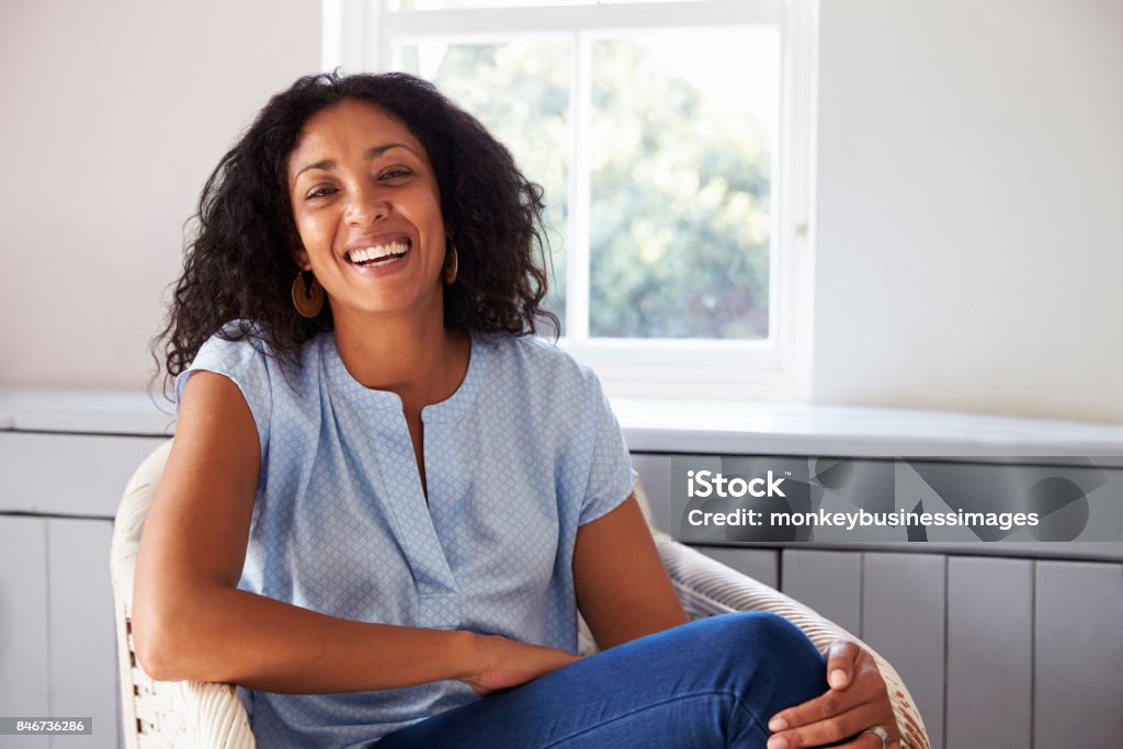 Portrait Of Woman Sitting In Chair At Home Women Stock Photo