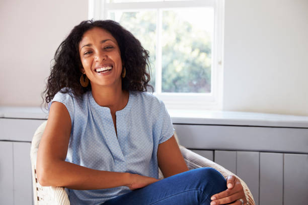 Portrait Of Woman Sitting In Chair At Home Portrait Of Woman Sitting In Chair At Home beautiful older black woman stock pictures, royalty-free photos & images
