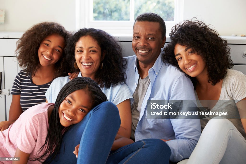 Portrait Of Smiling Family Relaxing On Seat At Home Teenager Stock Photo