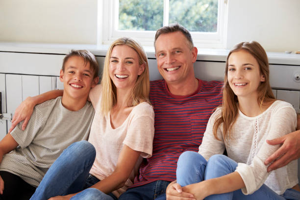 portrait de sourire détente familiale sur le siège à la maison - parent teenager caucasian teenage boys photos et images de collection