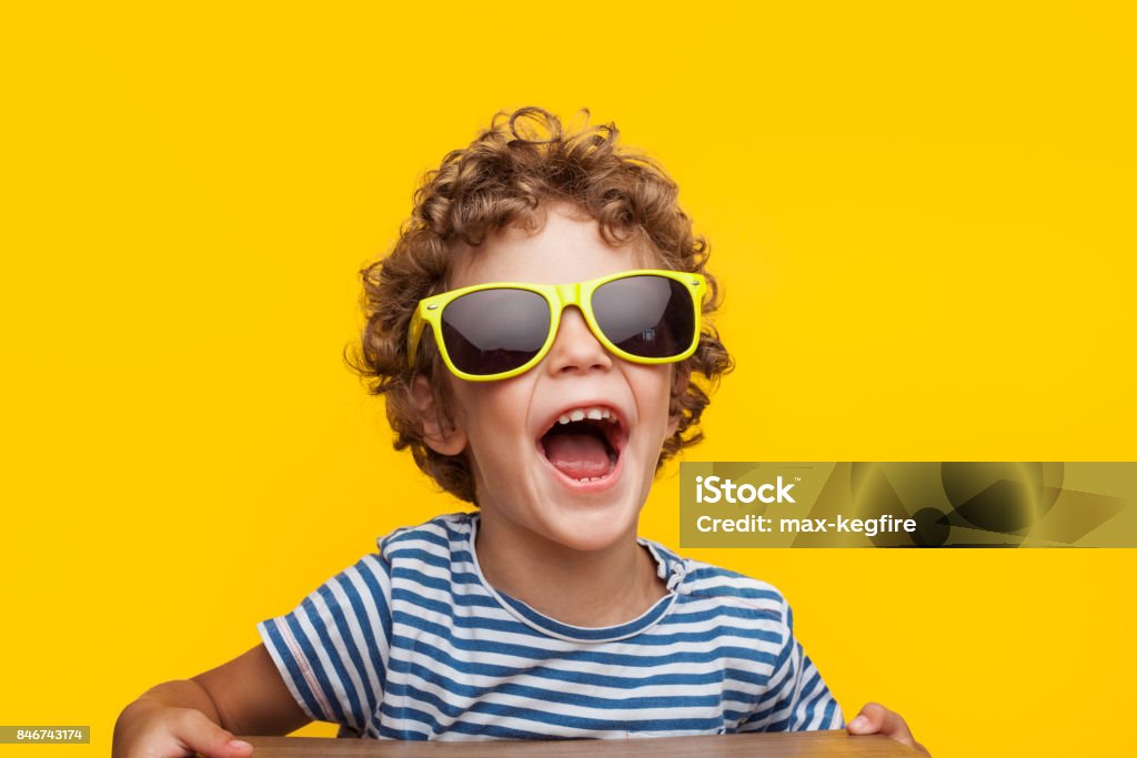 Adorable gamin dans lunettes de soleil brillants sur orange - Photo de Enfant libre de droits