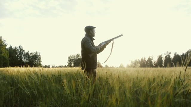 Hunter gets ready to shoot a weapon at golden hour