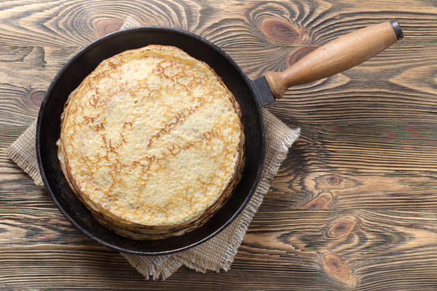 istock Stack of pancakes in a cast iron pan on a wooden table. Top view. Flat lay 846745646