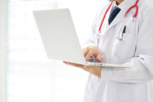 istock Unknown doctor posing using laptop with bright background, he is wearing a stethoscope . 846746664