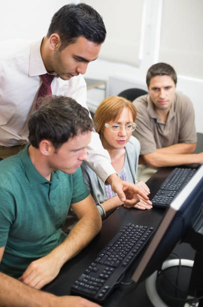 istock Teacher and mature students in computer room 846749444