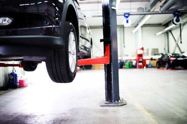Car on lift at car service Car on lift at car service hoisting photos stock pictures, royalty-free photos & images