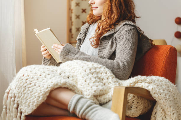 donna che legge un libro - wool blanket foto e immagini stock