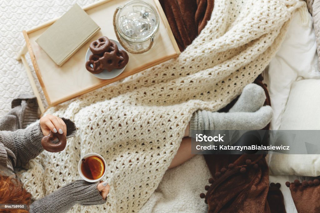 Woman spending night in bed Young woman spending a cold night in bed with blanket Tea - Hot Drink Stock Photo