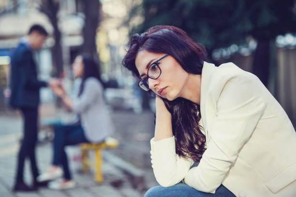 giovane donna triste seduta nel parco - emotional stress looking group of people clothing foto e immagini stock