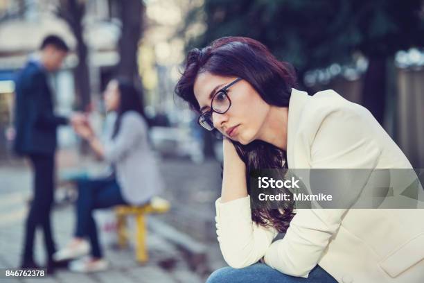 Young Sad Female Sitting In The Park Stock Photo - Download Image Now - Envy, Women, Looking Away