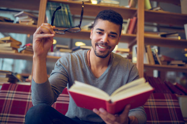 istock Smiling African American student  enjoying book reading in library 846763378