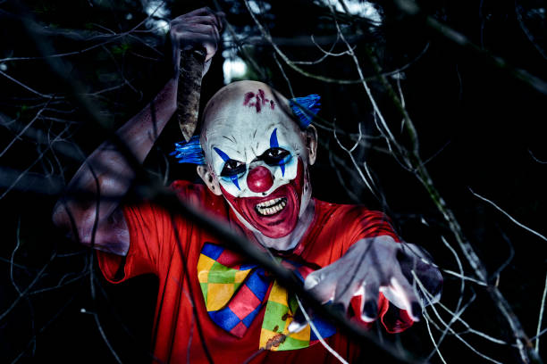 istock scary evil clown wielding a knife in the woods 846771296