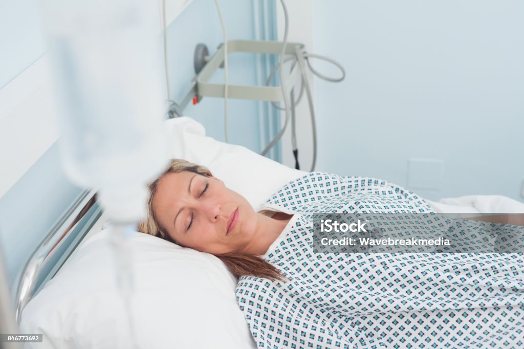 Female patient lying on a bed with closed eyes Female patient lying on a bed with closed eyes in hospital ward Bed - Furniture Stock Photo