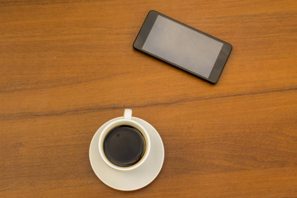 istock Cup of coffee and smartphone on wooden table. Top view 846775650