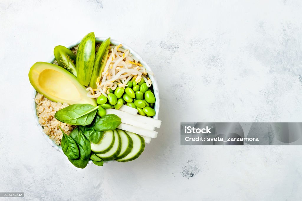 Vegan, detox green Buddha bowl recipe with quinoa, avocado, cucumber, spinach, tomatoes, mung bean sprouts, edamame beans, daikon radish. Top view, flat lay, copy space Healthy Eating Stock Photo