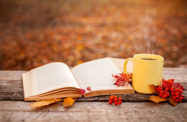 istock Yellow tea mug with warm scarf open book and apple 846782576