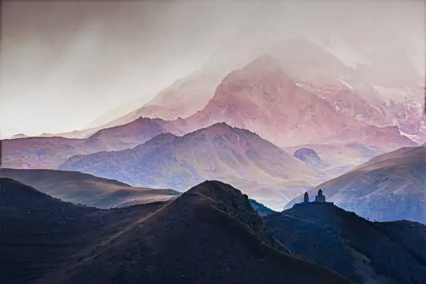 Landscape view of Tsminda Sameba church in Kazbegi during storm, Caucasus mountains, Georgia