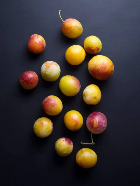 Fresh multicolored mirabelles plums (or mirabelle prunes) isolated on black background