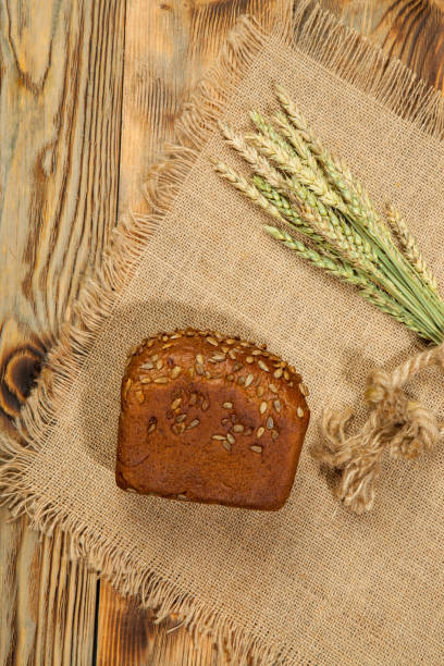 istock Fresh round bread on black wooden board, top view with copyspace 846796230