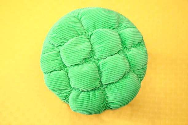 Details of a green ottoman on yellow background