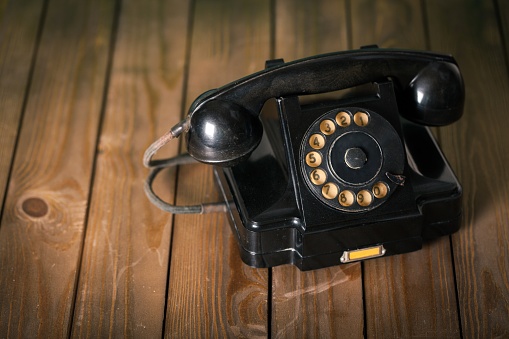 Retro black telephone on wooden background