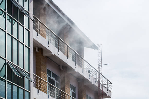 The smoke coming out of the front of the high building due to a fire. stock photo