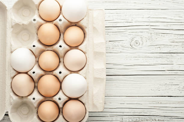 istock chicken eggs in cardboard box on white wooden background 846830836