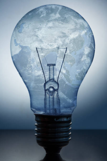 istock Close up of big light bulb standing with earths surface in it 846837340