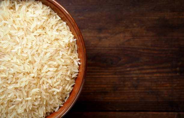 istock Rice in a bowl on textured wood 846841206