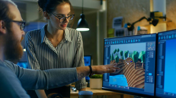 istock Male Game Developer Talks with Artistic Female Level Designer. Two Displays Show Totally Original Game. They Work in a Creative Office Loft. 846843174