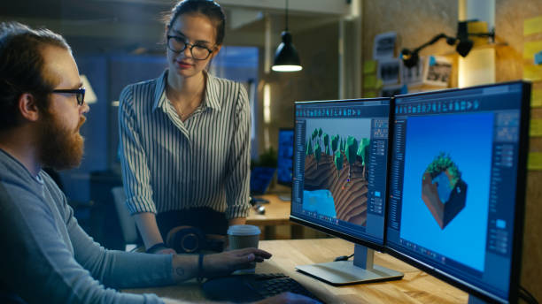 istock Male Game Developer Talks with Artistic Female Level Designer. Two Displays Show Totally Original Game. They Work in a Creative Office Loft. 846843184