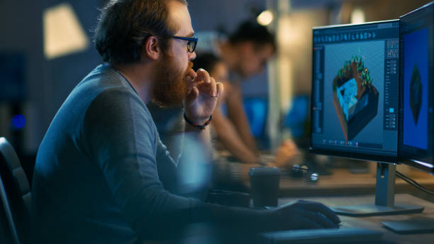 istock Male Game Developer works on a Level Design on His Personal Computer with Two Displays. He Works for in a Creative Office Environment with Very Talented Colleagues. 846843256