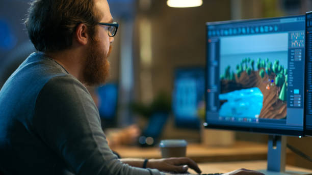 istock Male Game Developer Works on a New Level Design. He's Handsome Bearded Man with Glasses and Works in a Creative Office with other Talented People. 846843286